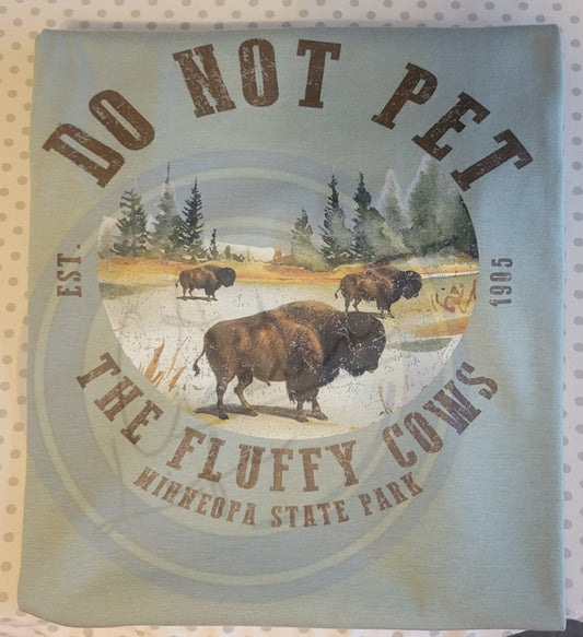State Park Inspired tee with image with bison and text 'Do Not Pet the Fluffy Cows' on a scenic background.